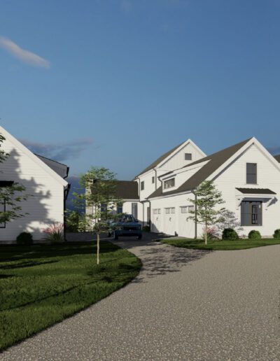 A winding gravel driveway leads to two white, two-story houses with gray roofs, surrounded by neatly trimmed grass and small trees under a blue sky.