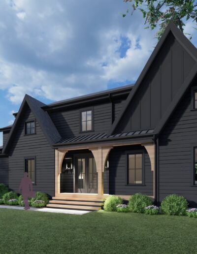 A two-story, dark-colored house with an A-frame design features a front porch, multiple gables, and well-maintained landscaping. A person stands near the steps leading to the front door.